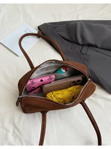 Brown leather shoulder bag interior detail showcasing spacious capacity with daily essentials.