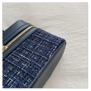Close-up detail of a navy blue tweed and leather box handbag showcasing exquisite texture and zipper.