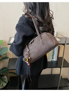 Chic vintage style brown shoulder bag detail, elegant everyday baguette purse for women.