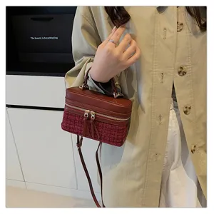 Detailed view of the vintage style red tweed and leather box handbag held by model.