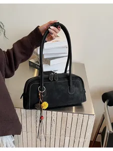 Detailed view of the black retro baguette shoulder bag with double zipper and cute pendant.