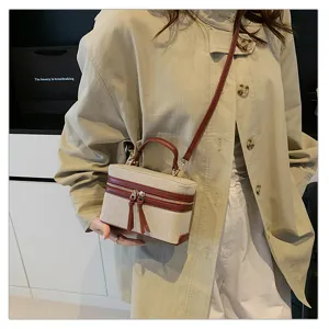 Detail shot of vintage colorblock box bag with top handle and crossbody strap, chic design.