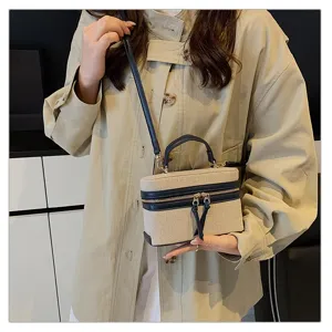 Close-up view of the chic contrast canvas box handbag featuring top handle and strap.