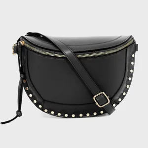 Close-up detail of black leather crescent crossbody bag with gold studs and zipper hardware.