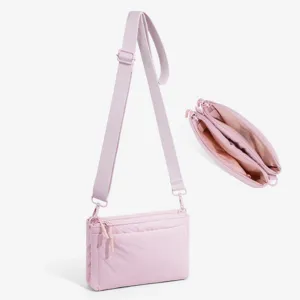 Detailed view of the pink multi-compartment crossbody bag showing interior and strap.
