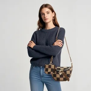 Detailed shot of stylish checkerboard canvas messenger bag and small pouch set worn by model.