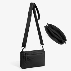 Black multi-compartment crossbody bag detail showing zipper and interior storage capacity.