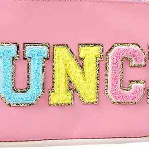 Pink lunch bag detail shot showing colorful embroidered letter patches, high quality student handbag.