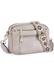 Detailed view of grey PU leather crossbody bag with woven wide strap and gold hardware.