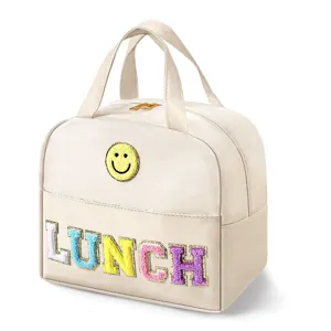 Insulated lunch bag with cute smiley face patch and colorful LUNCH letters for daily meals.