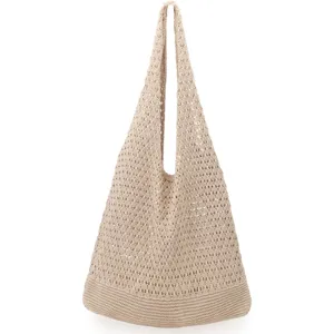 Close-up detail of beige hollow knit crochet tote bag shoulder strap and woven mesh fabric texture.