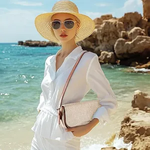 Stylish women woven shoulder bag detail view on beach, trendy summer handbag feature.