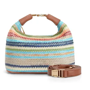 Detailed view of the stylish striped straw shoulder bag with brown leather handles.