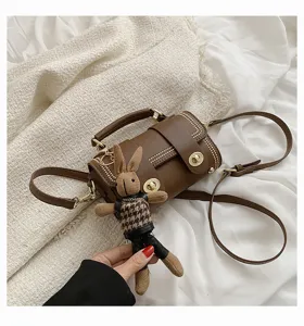 Retro bruine cilinder crossbody tas met schattig gebreid konijnenhangertje, stijlvolle tas.