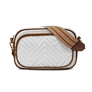 White crossbody bag with chevron quilting and patterned webbing strap for women daily use.