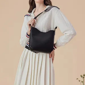Black leather bucket shoulder bag for women, casual commuter handbag with wide strap.