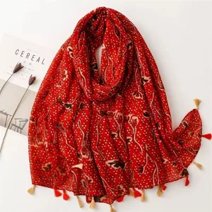 Detail view of the red printed cotton linen scarf with tassel details, vintage floral pattern.