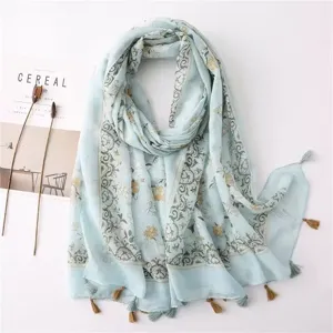 Light green cotton linen scarf, bohemian floral print, elegant tassel edge design detail.