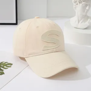 beige cotton baseball cap detail showing textured letter embroidery and curved brim
