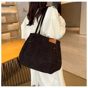 Black corduroy tote bag detail view, large capacity shoulder bag with front pocket design.