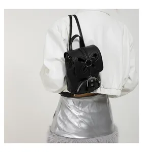 Vue détaillée du mini sac à dos noir élégant avec découpe papillon et boucle en métal.