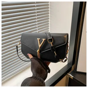 Stylish black shoulder bag with a gold V logo and tassel detail for daily commuting use.