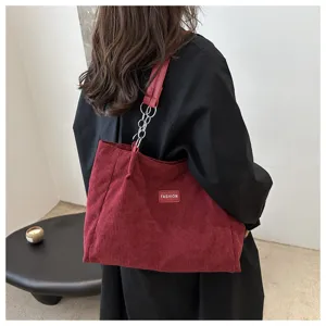 Kord Shopper Detail mit weinrotem Stoff, Kettengriff und modischem Label für Alltag.