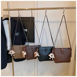 Vue détaillée du sac seau bandoulière élégant pour femme avec un charmant pendentif.