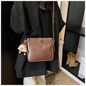 Sac seau en cuir marron, sac à bandoulière chic pour femme, accessoire de mode élégant.