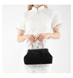 Detail shot of vintage Chinese style black handbag with silver metal lock and chain strap.