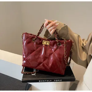 Detailansicht einer stilvollen gesteppten Ledertasche mit edlen Kettenriemen für Damen.