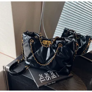 Elegante schwarze gesteppte Umhängetasche aus Lackleder mit Goldkette und Vintage-Drehverschluss.