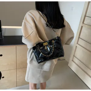 Detailansicht der stilvollen schwarzen gesteppten Schultertasche mit goldener Kette.
