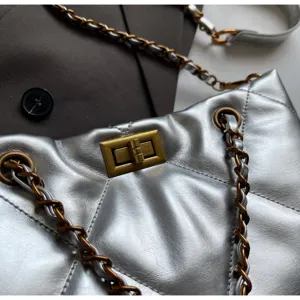 Nahaufnahme der silbernen metallischen gesteppten Handtasche mit Retro-Drehverschluss Kette.