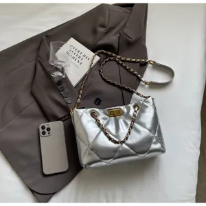 Detailansicht der silbernen gesteppten Umhängetasche mit Metallkette und Drehverschluss.