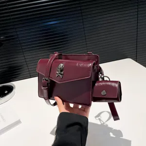 Burgundy PU leather small square crossbody bag with skull pendant and mini pouch.