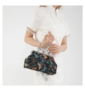 Vintage butterfly embroidered clutch handbag with metal clasp and chain strap detail.