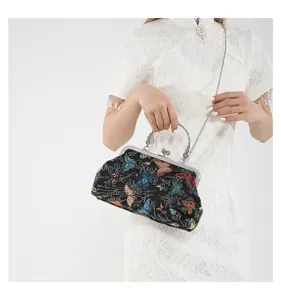 Detailed view of vintage Chinese style embroidered butterfly pattern handbag with metal kiss lock.