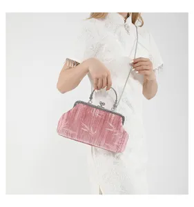 Chic pink velvet vintage handbag with metal kiss lock and chain strap for stylish evening wear.