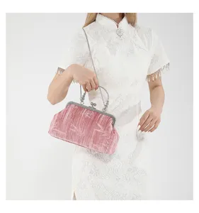 Chic pink velvet clutch detail view, vintage metal clasp, elegant style handbag shot.
