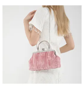Detailed view of vintage pink velvet kiss-lock handbag with metal chain strap and top handle.