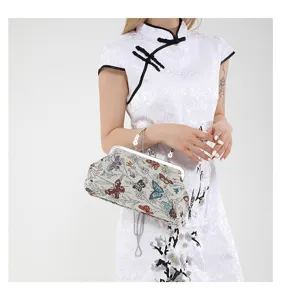 Chinese style vintage butterfly tapestry clutch bag with metal kiss lock and chain strap details.
