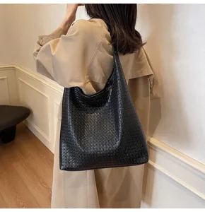 Vue détaillée montrant la texture tissée et la grande capacité du sac porté épaule noir.