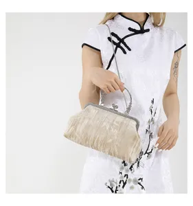 Velvet kiss-lock handbag detail showing exquisite metallic frame and vintage chain strap.