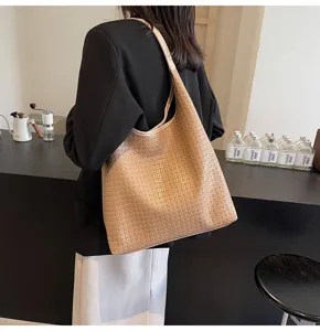 Vue détaillée du sac porté épaule hobo tissé marron, texture premium pour le style quotidien.