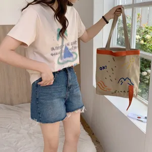 Sac cabas en toile décontracté avec sangle contrastée et broderie colorée pour l'usage.