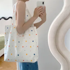 Vista dettagliata di una borsa in tela con pois colorati per l'uso quotidiano e gli studenti.