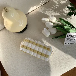 Detailaufnahme eines süßen, fluffig gestreiften Federmäppchens in Creme, Lifestyle.