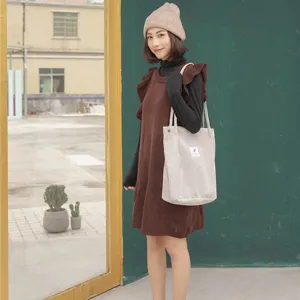 Corduroy tote bag detail showing soft fabric texture and casual shoulder carry style in daily outfit.