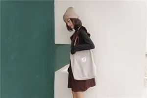 Detailed view of the casual corduroy tote bag worn by model, showing large capacity.